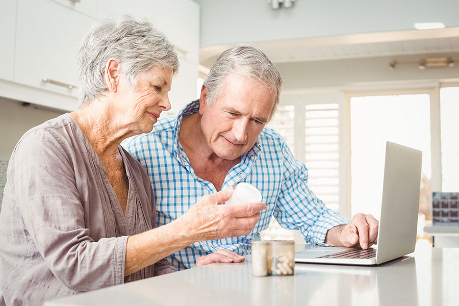 elderly couple looking at pill bottle